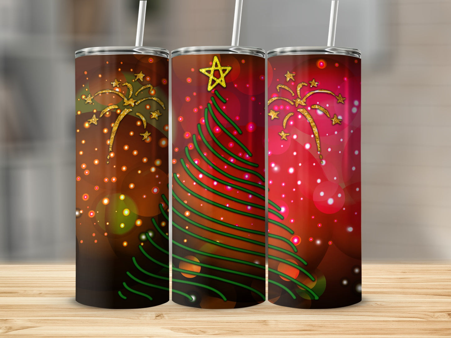 Three tumblers with a Christmas tree and star design on a wooden surface.