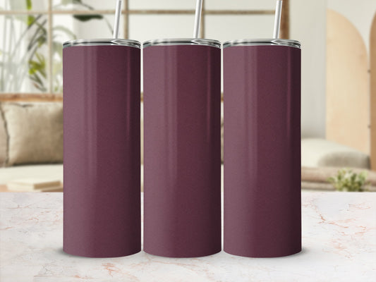 Three plain maroon tumblers with straws on a marble counter.
