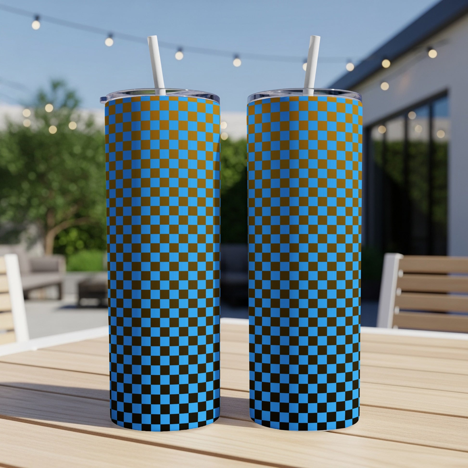 Two tumblers with a blue and brown checkered pattern sit on a table.