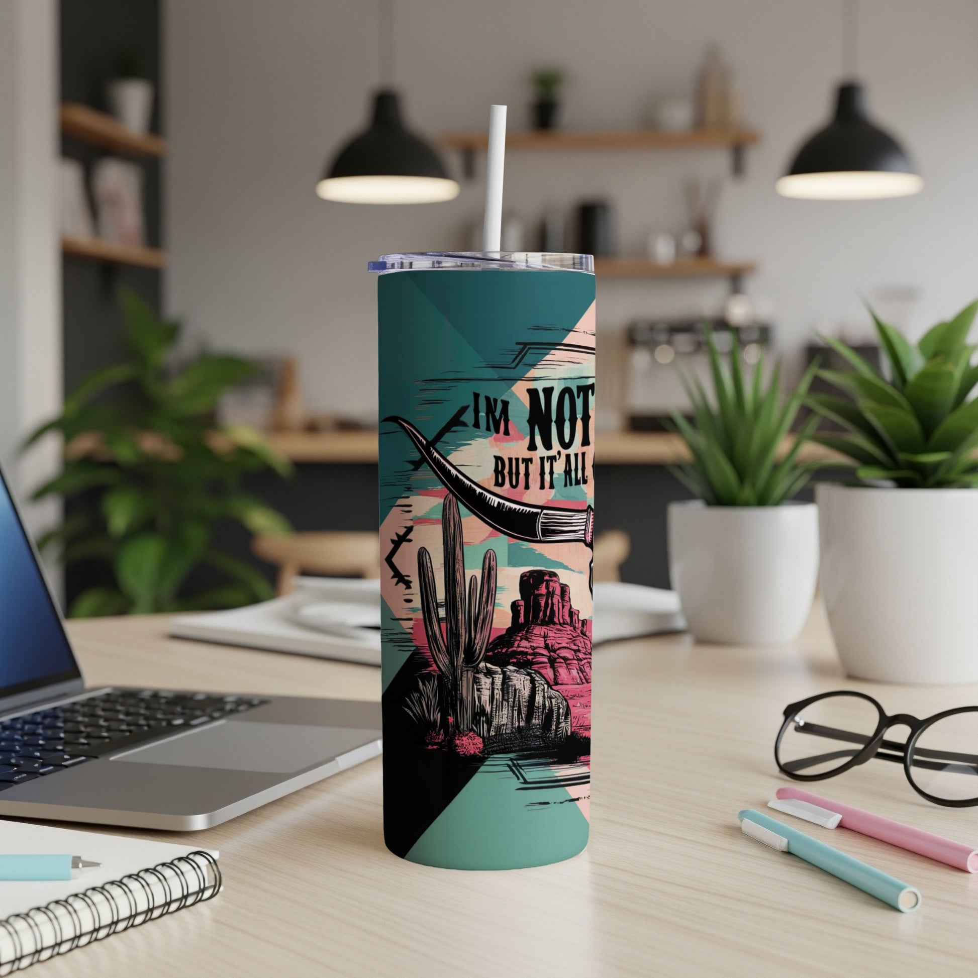 Teal tumbler with desert scene and bull horn, reading "I'm not but it all".