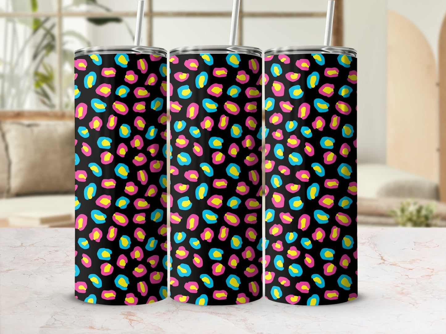 Three tumblers with a black background and a bright leopard print of pink, yellow, and blue.