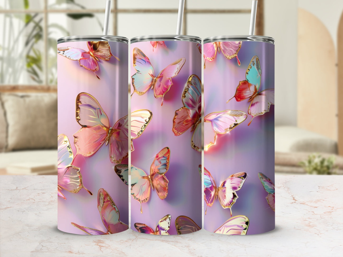 Three iridescent butterfly patterned tumblers with straws on a marble surface.