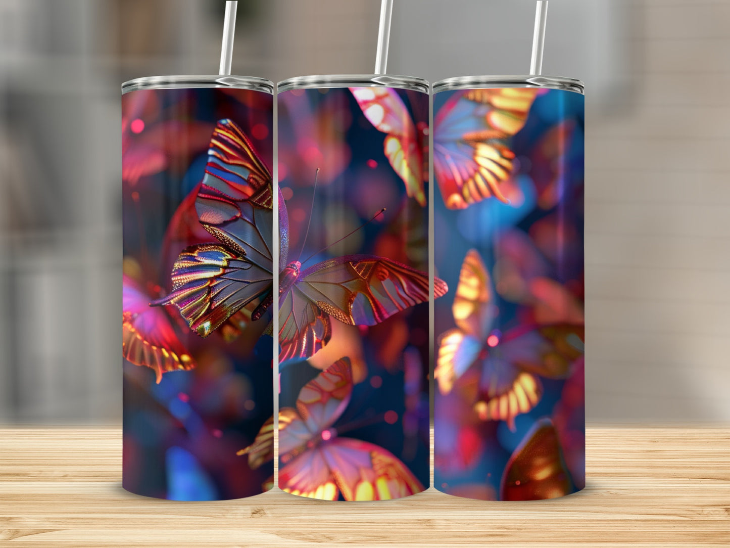 Three tumblers with colorful butterfly designs, set on a wooden surface.