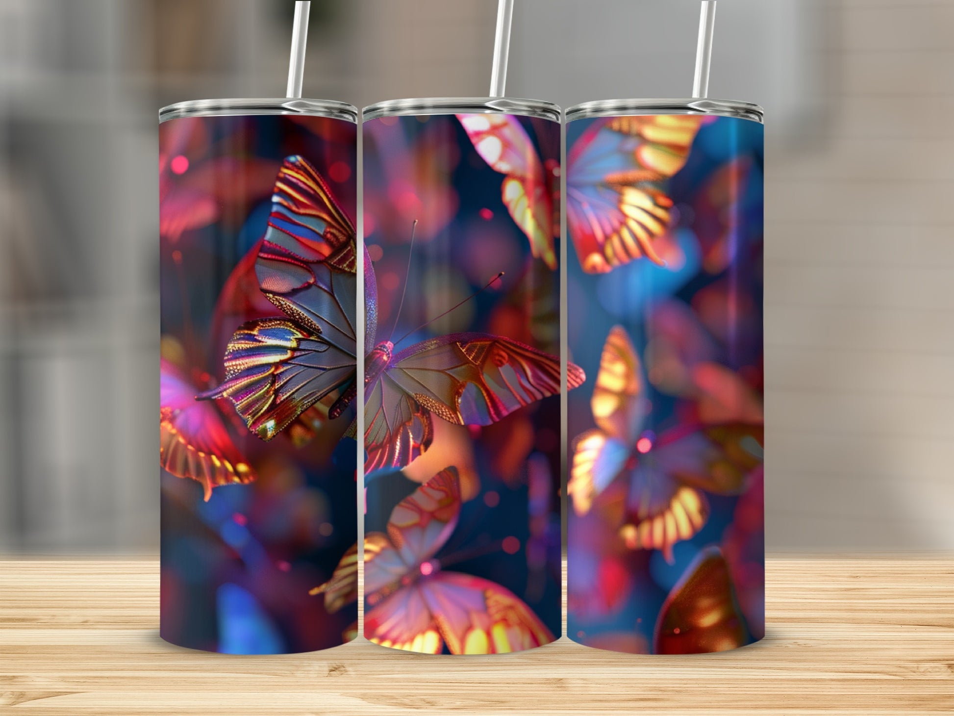 Three tumblers with colorful butterfly designs, set on a wooden surface.