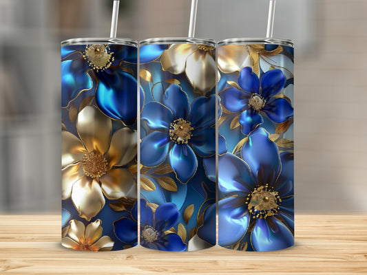 Three blue and gold floral tumblers with straws on a wooden surface.