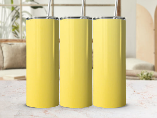Three yellow stainless steel tumblers with straws stand on a marble surface.