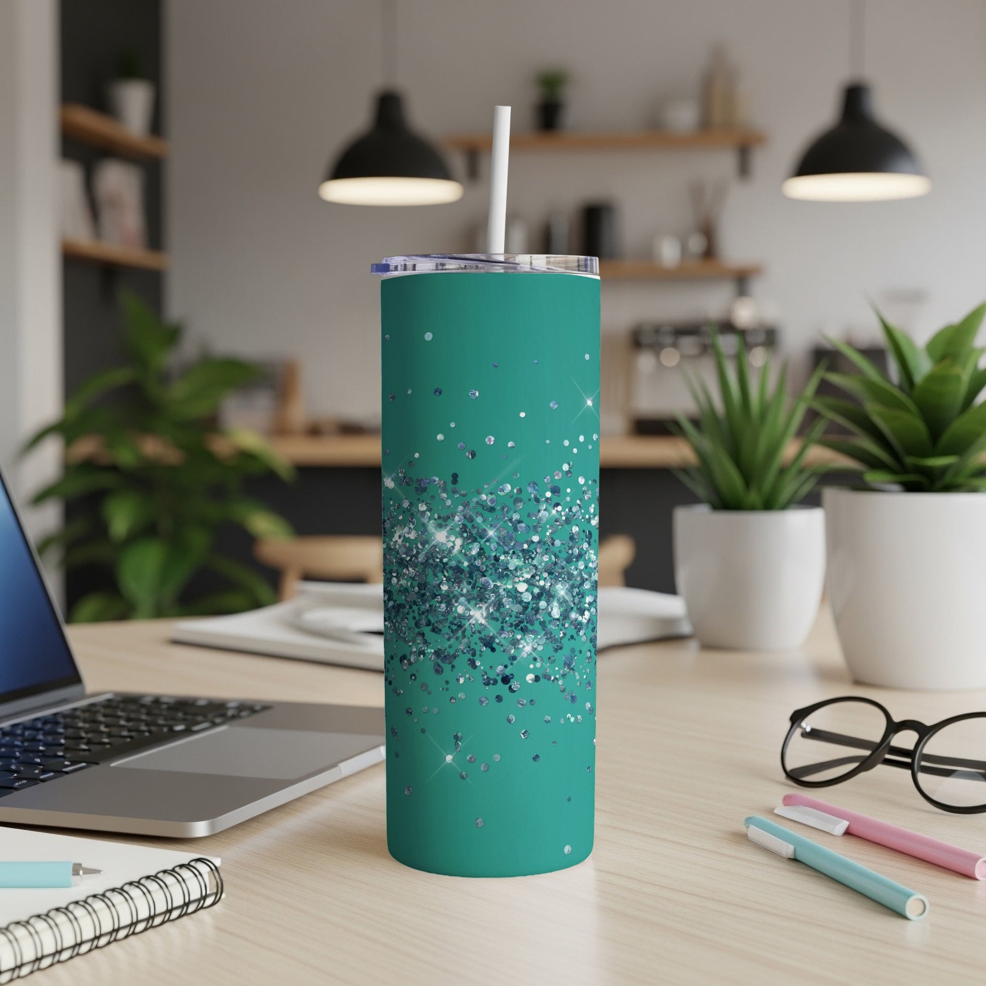Teal tumbler with scattered silver glitter design and white straw.