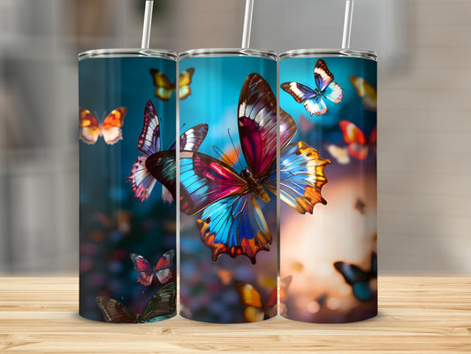 Three tumblers with colorful butterflies and floral elements on a wooden surface.