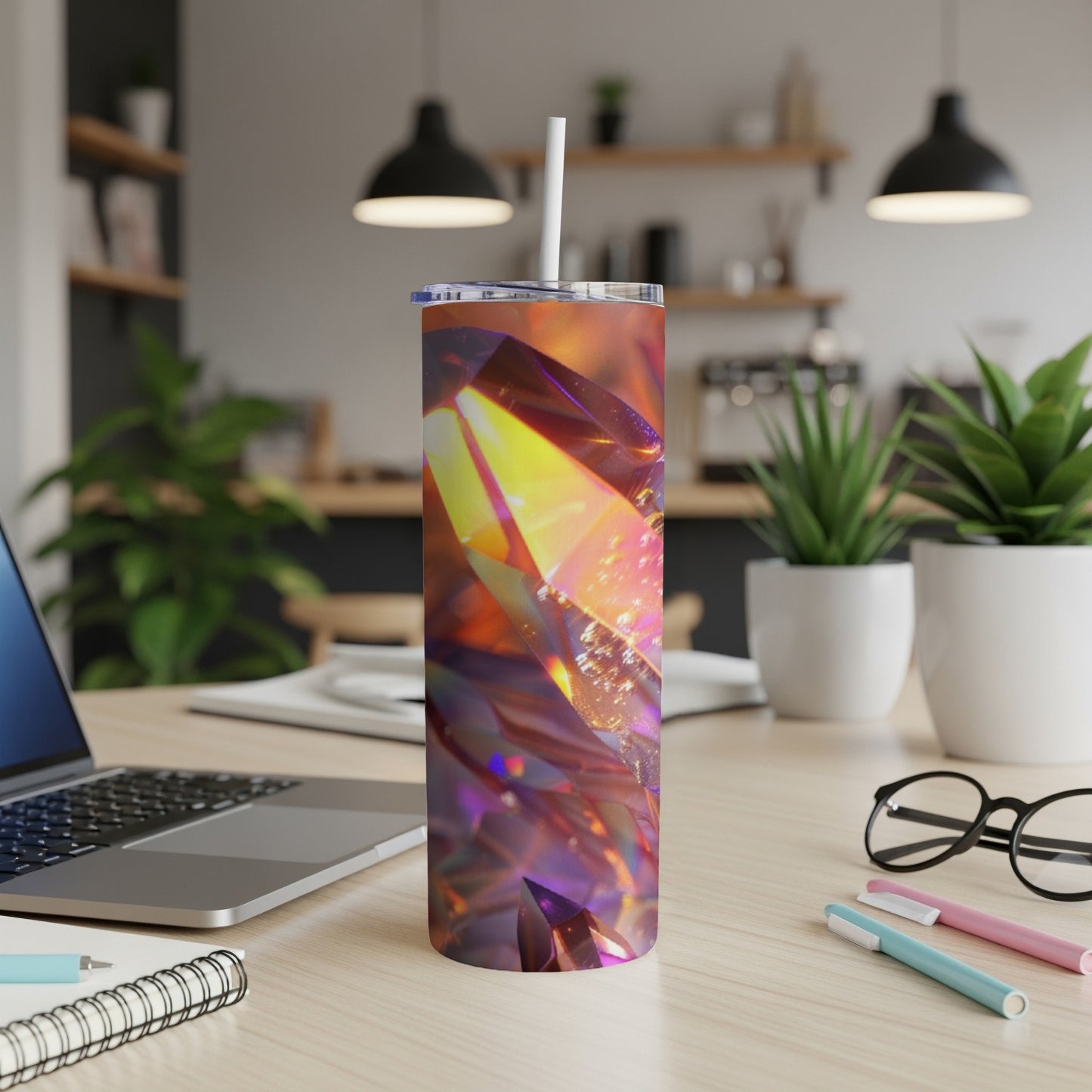 Tumbler with colorful, faceted gemstone design on a desk.