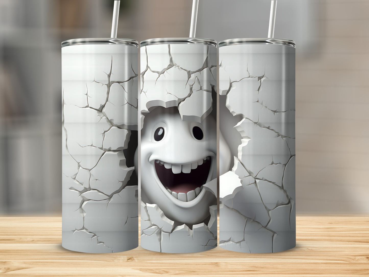 Three tumblers featuring a smiling face breaking through a cracked wall design.
