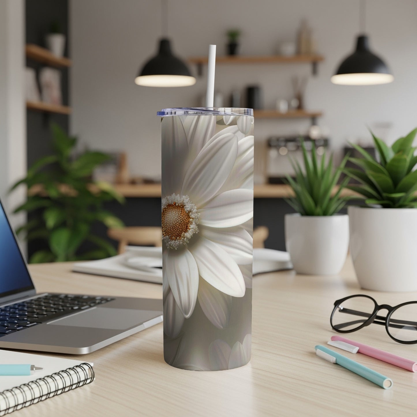 White daisy flower design on a tall, slim tumbler with a straw.