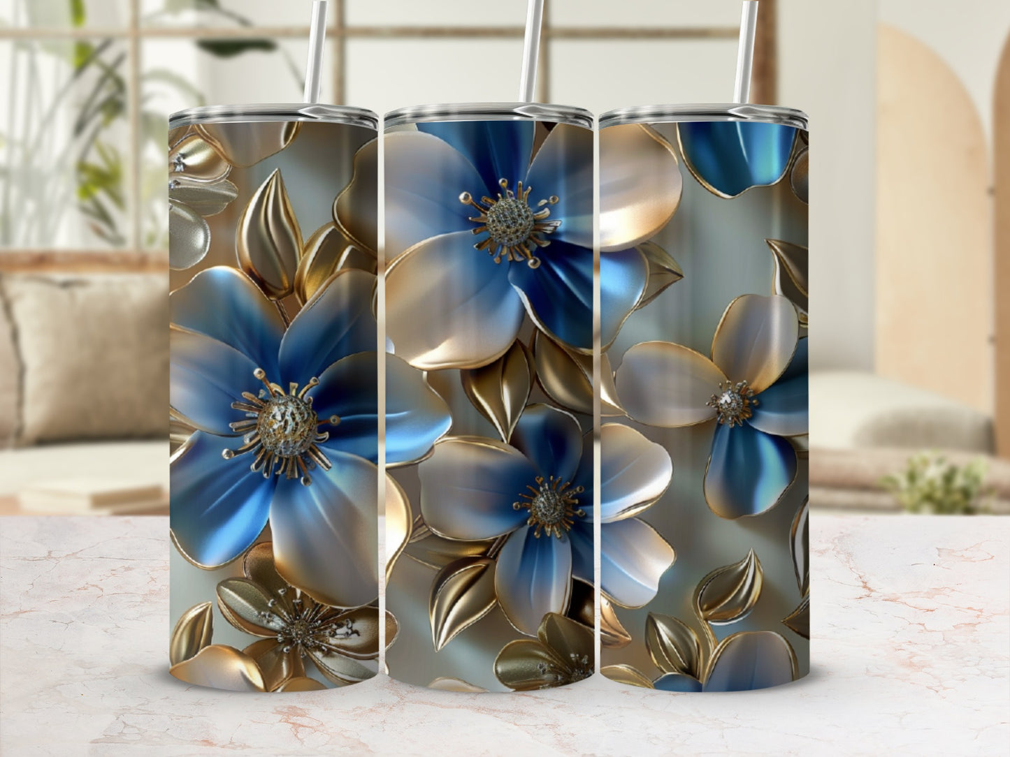 Three iridescent blue floral tumblers with gold accents and straws on a marbled surface.