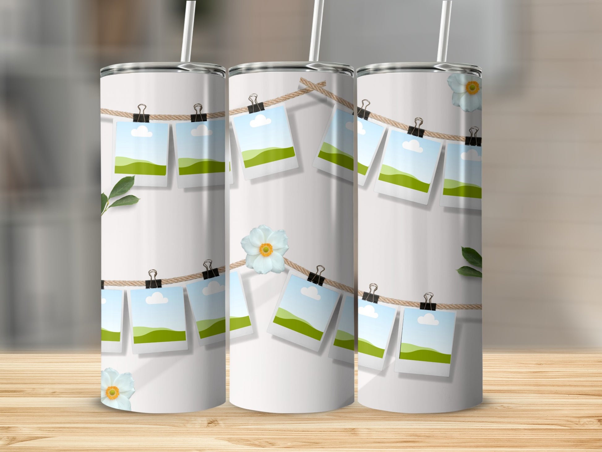 White tumblers with a string of photos, greenery, and flowers.