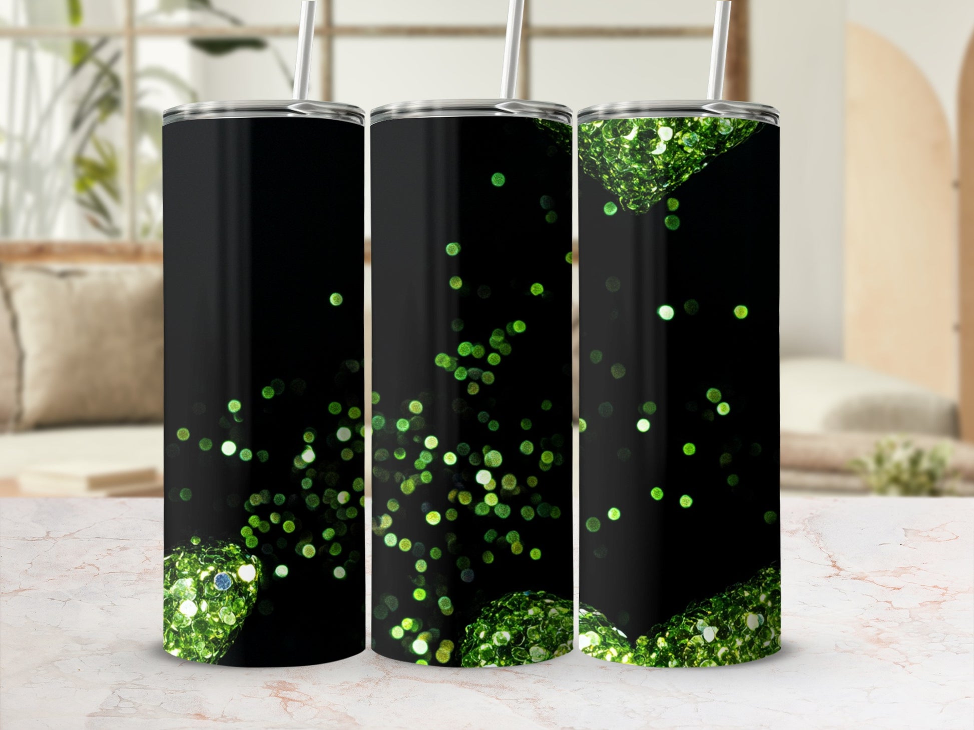 Three black tumblers with green glitter and spherical accents.