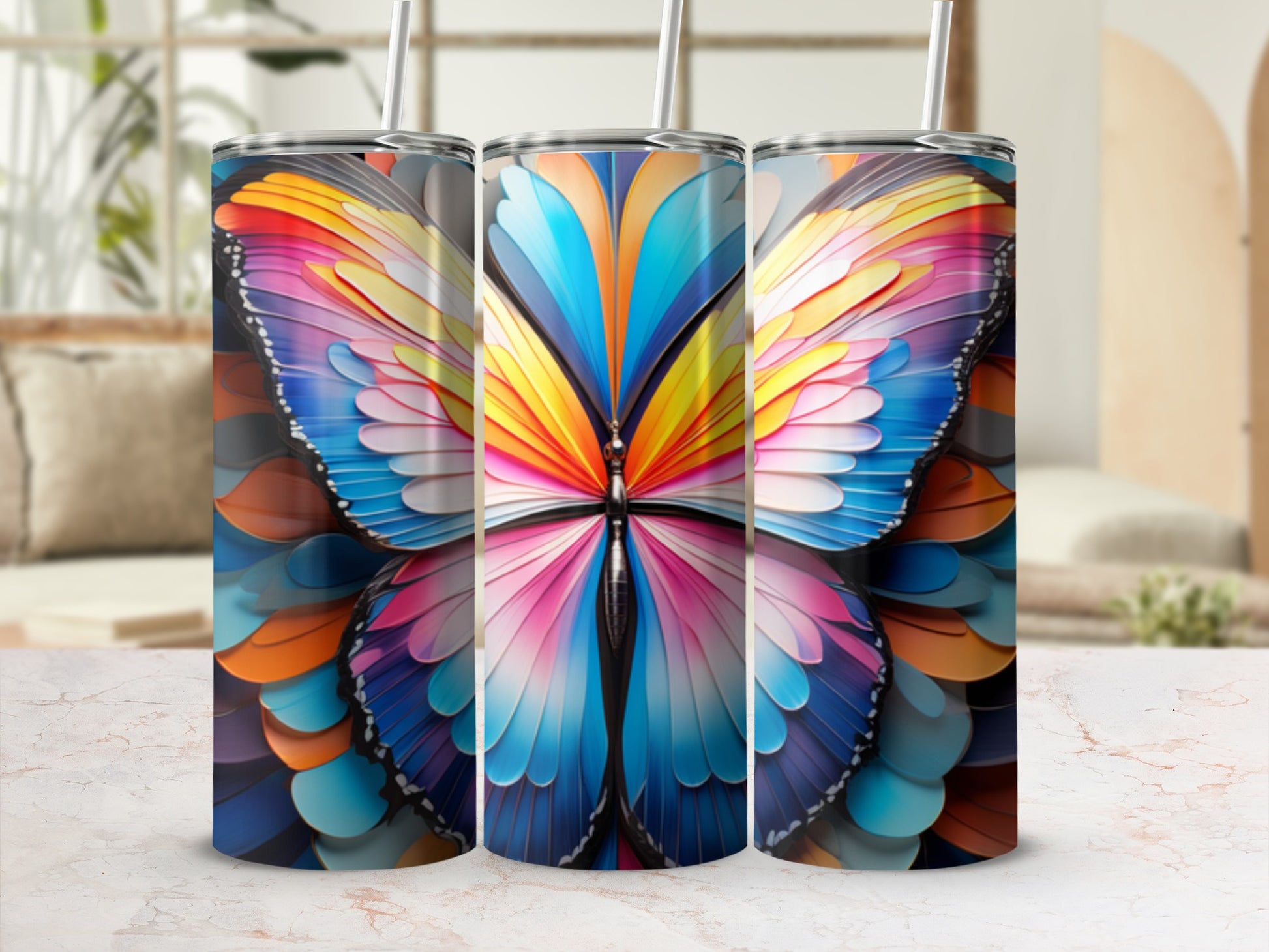 Three tumblers with colorful butterfly wing designs on a table.
