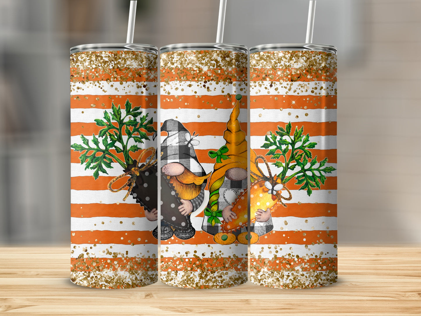 Three decorative tumblers with gnome and carrot designs on an orange and white striped background.