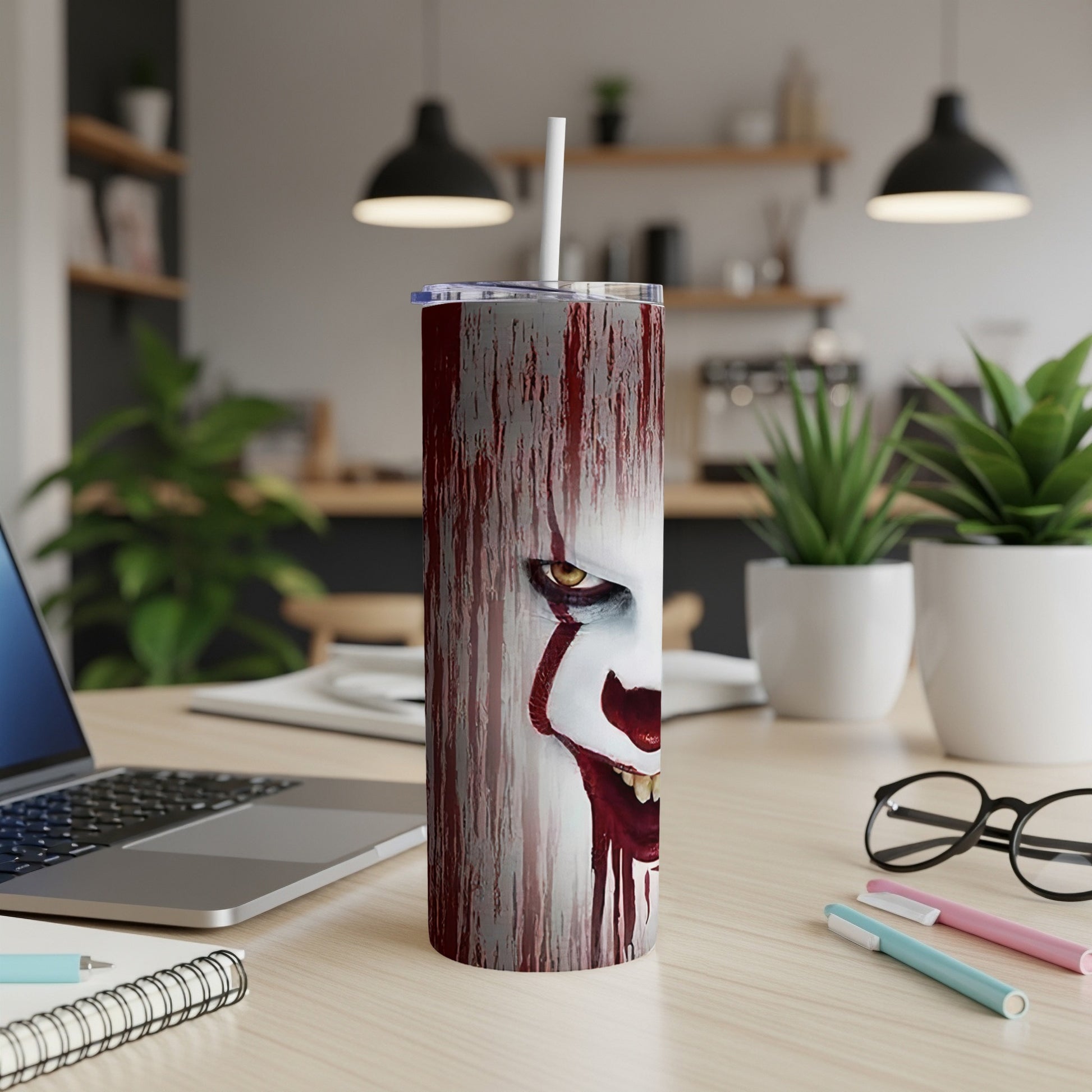 Pennywise the clown face design on a stainless steel tumbler with straw.