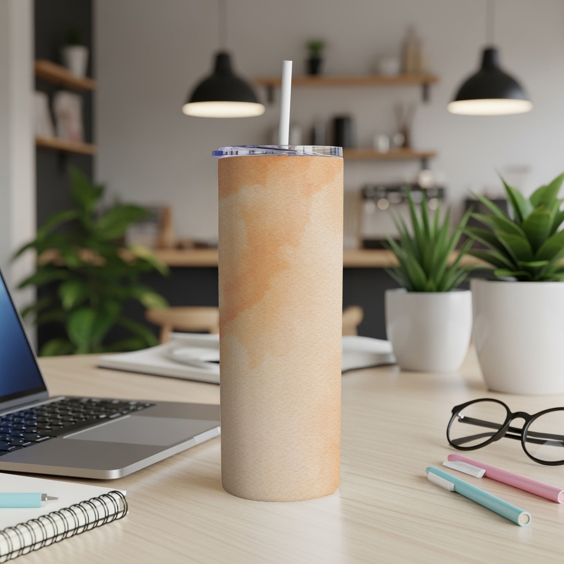 Beige watercolor tumbler with white straw on a desk.