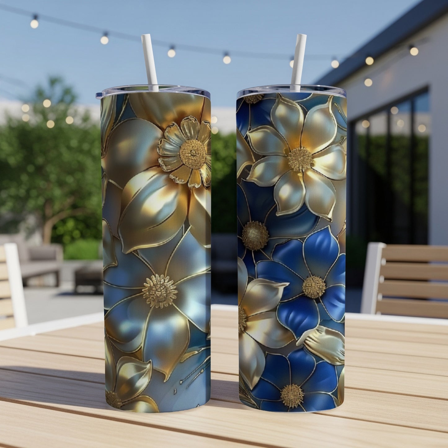 Two tumblers with floral designs, one gold, one blue, on a table.