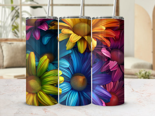 Three colorful floral pattern tumblers with straws on a marble counter.