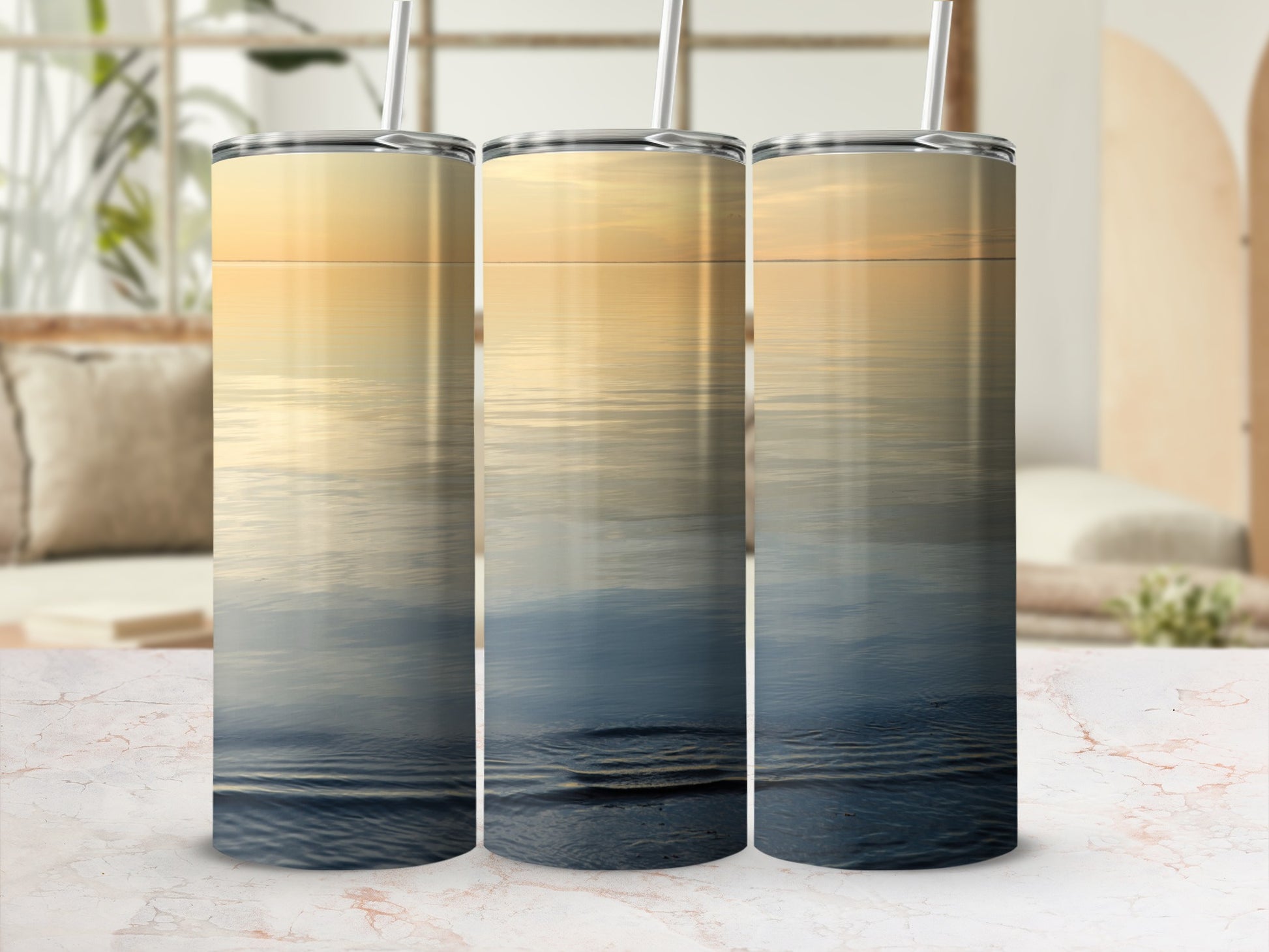 Three tumblers with a sunset over water design.