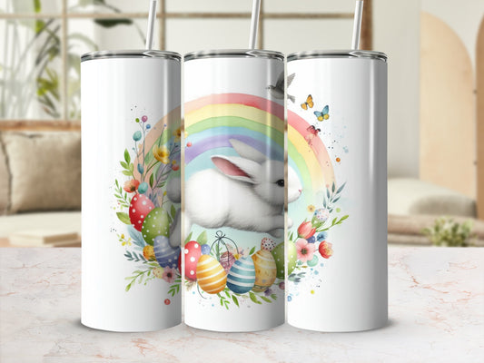 White bunny and colorful Easter eggs on a rainbow background.