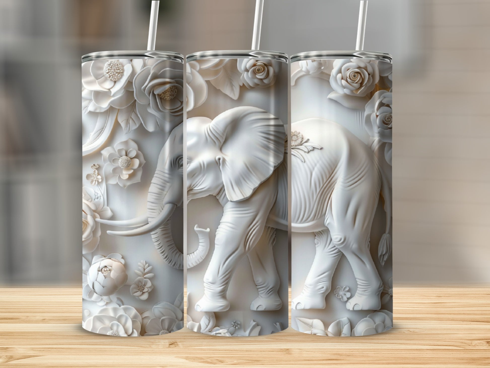 Three white embossed tumblers featuring elephants and floral designs.