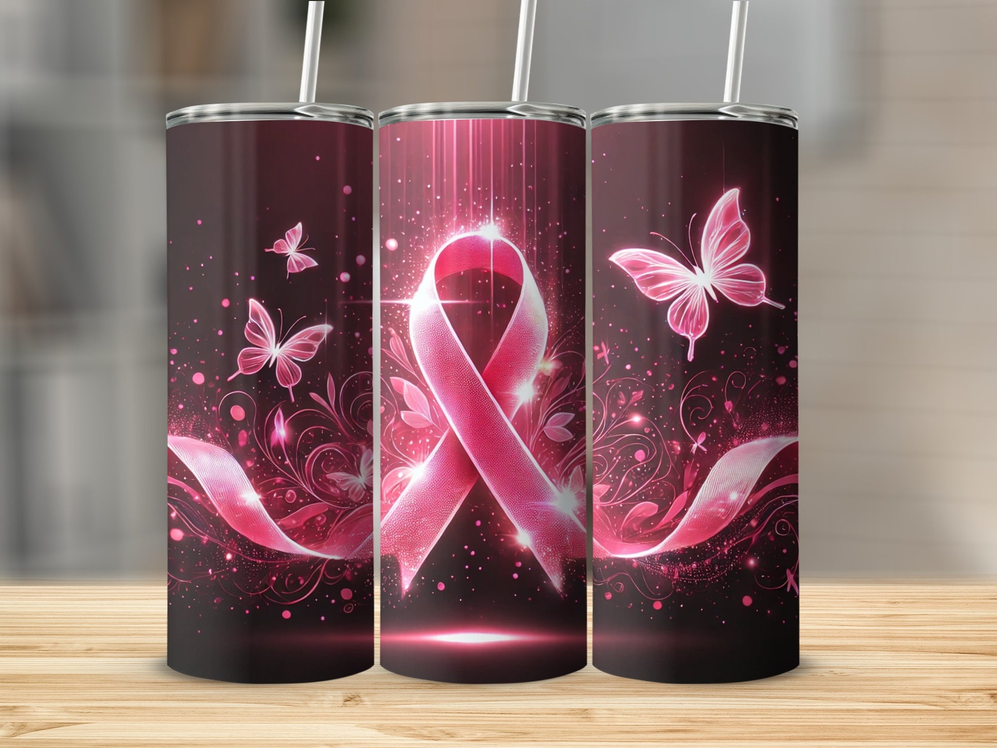 Pink ribbon with butterflies and sparkles, three tumblers on a wooden surface.