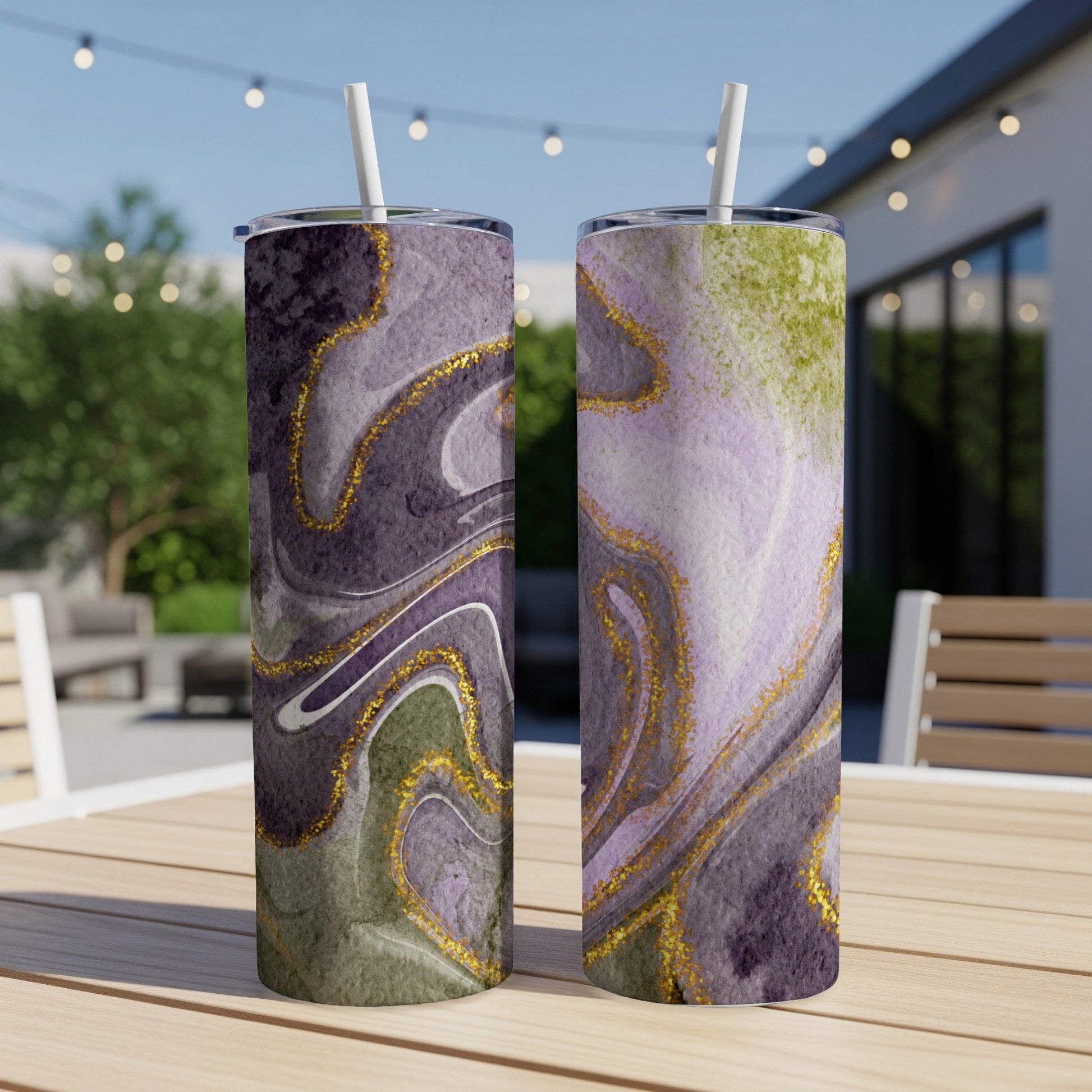 Two tumblers with purple, green, and gold marbled patterns on a wooden table.