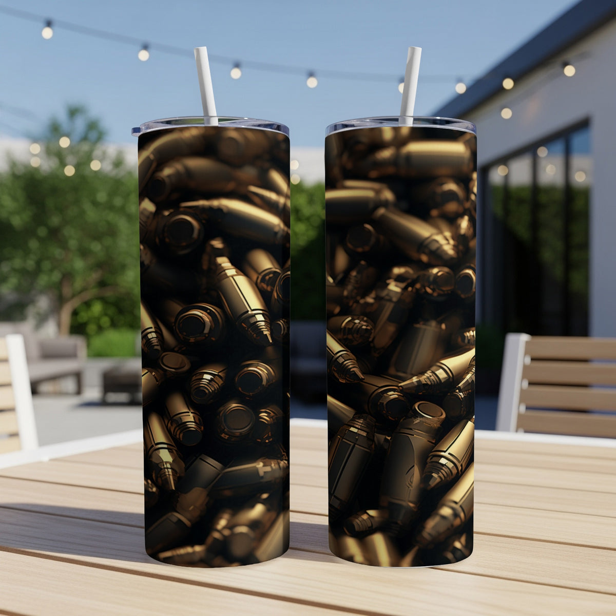 Two tumblers with a close-up design of golden bullet casings on a patio table.