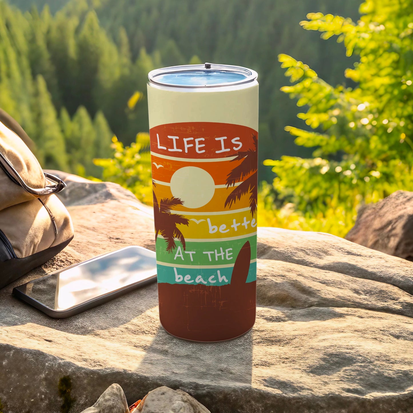Tumbler with "Life is better at the beach" text and sunset graphic.