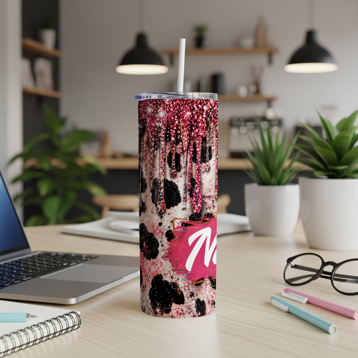Tumbler with pink glitter drips, cow print, and a large white 'M'.
