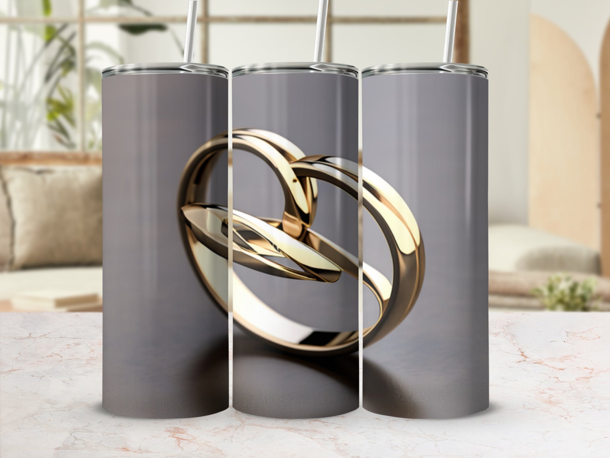 Three tumblers showing a gold interlocking ring design on a marble surface.