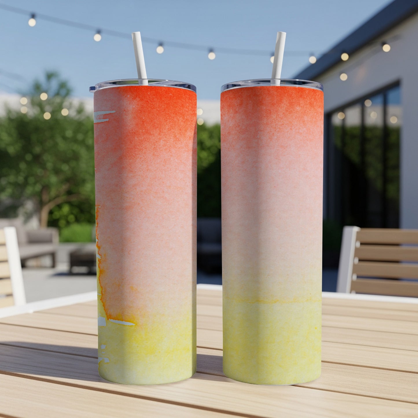 Two ombre tumblers with orange fading to yellow, on a table.