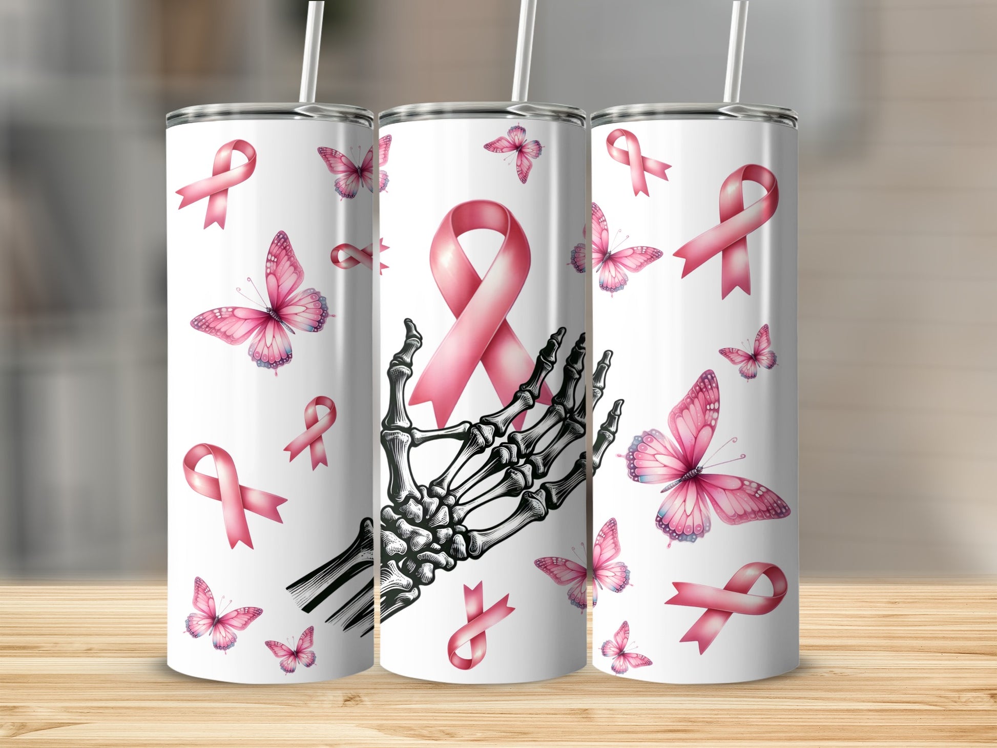 Three tumblers with pink ribbons and butterflies, one with a skeleton hand.