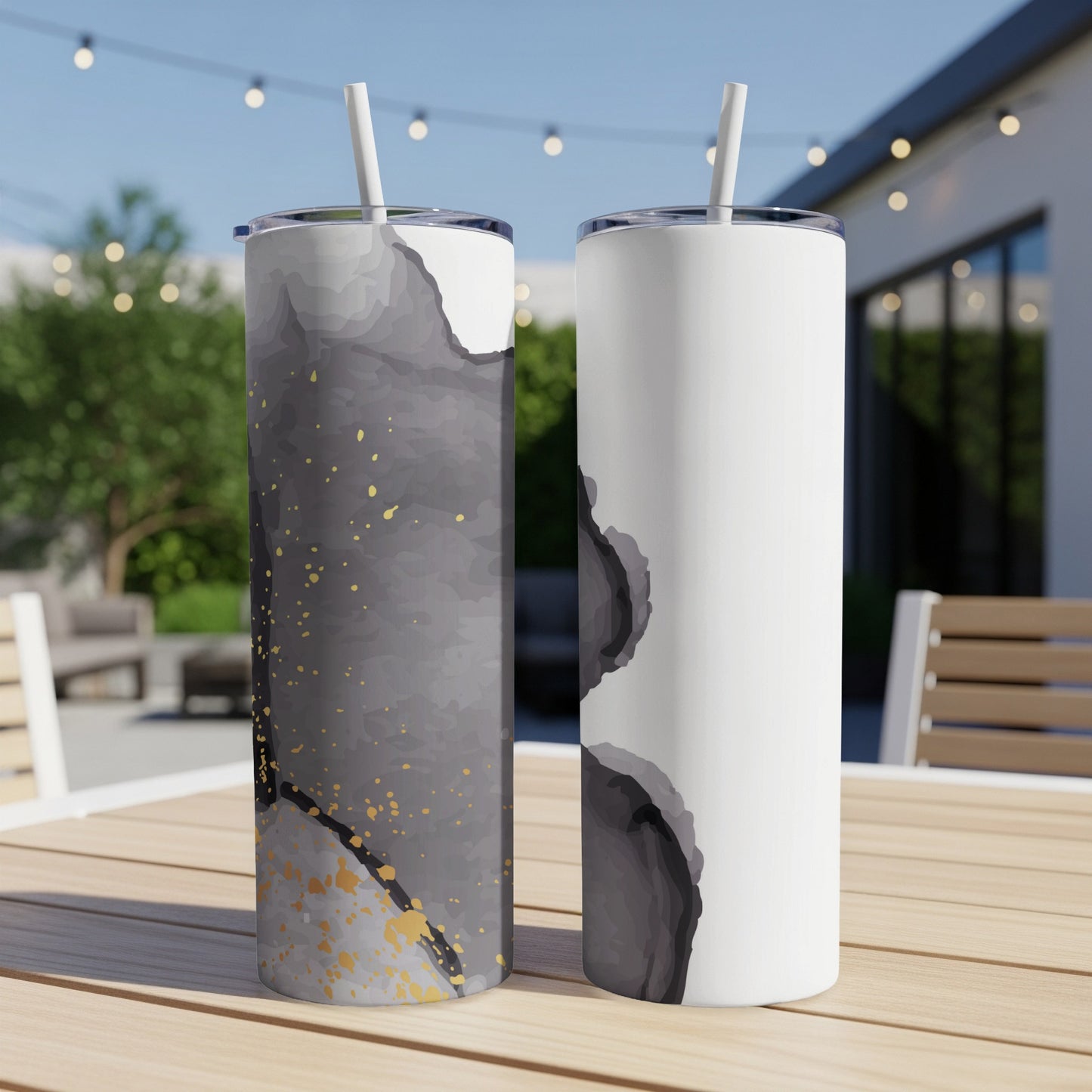 Two tumblers on a table, one dark abstract design, one white abstract design.