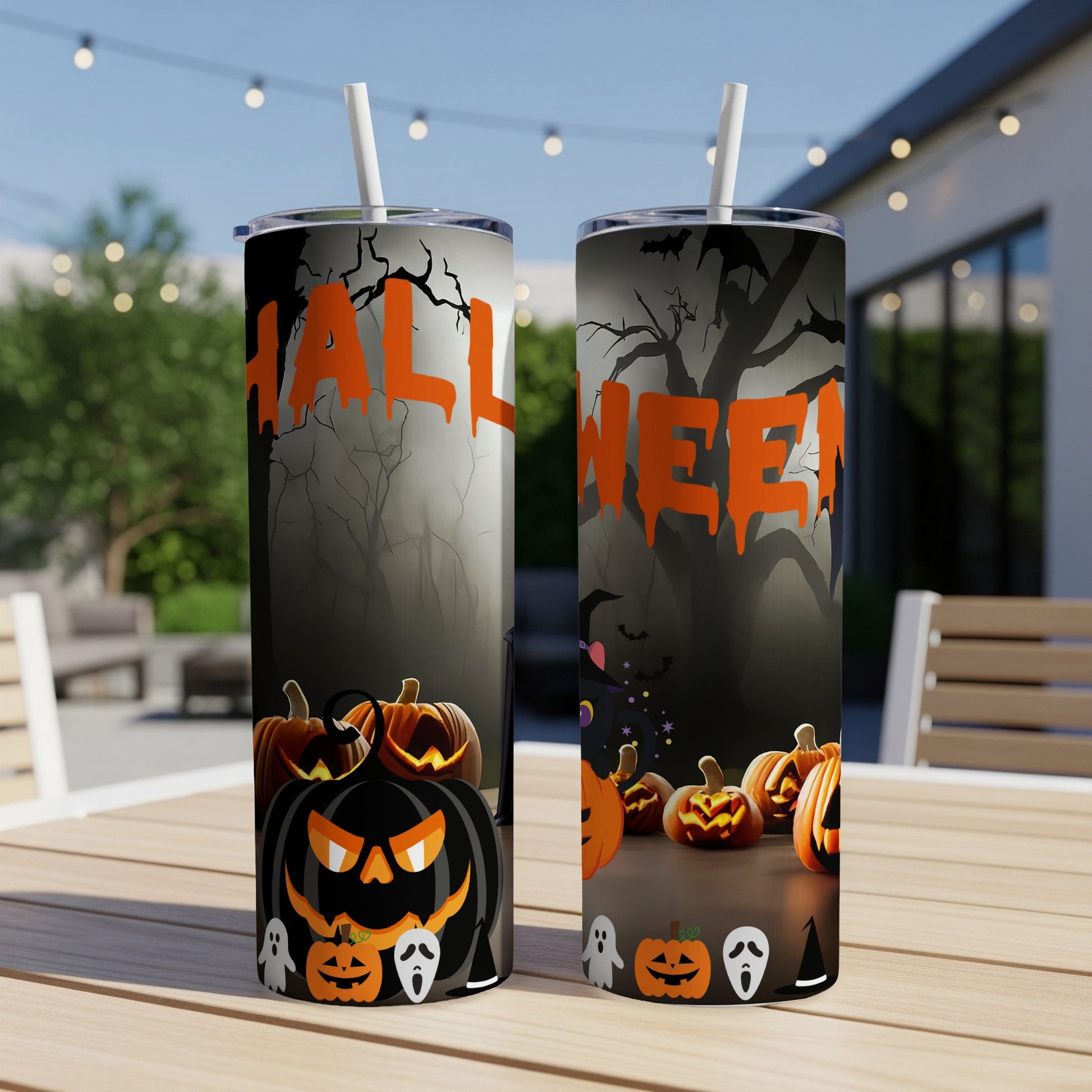 Halloween themed tumblers with pumpkins, ghosts, and bats on a table outdoors.