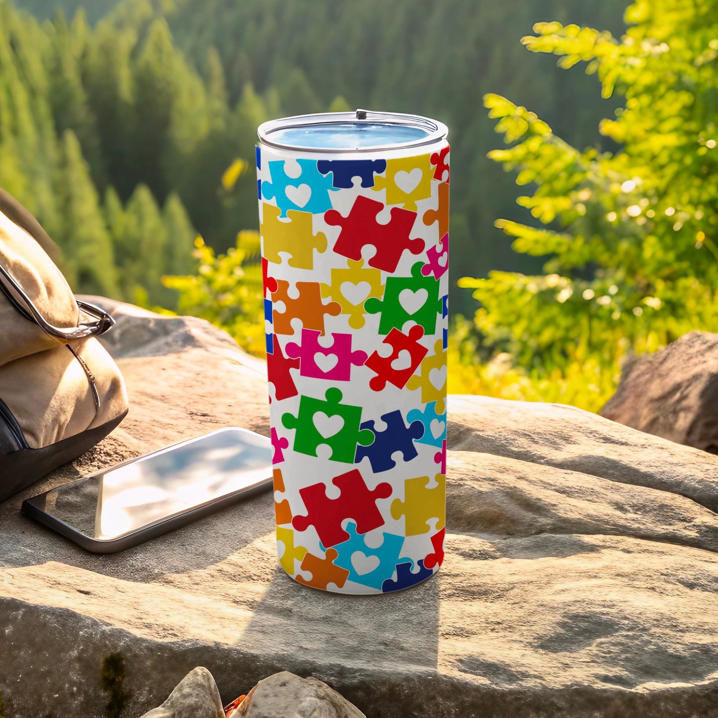 White tumbler with colorful puzzle pieces and heart shapes.