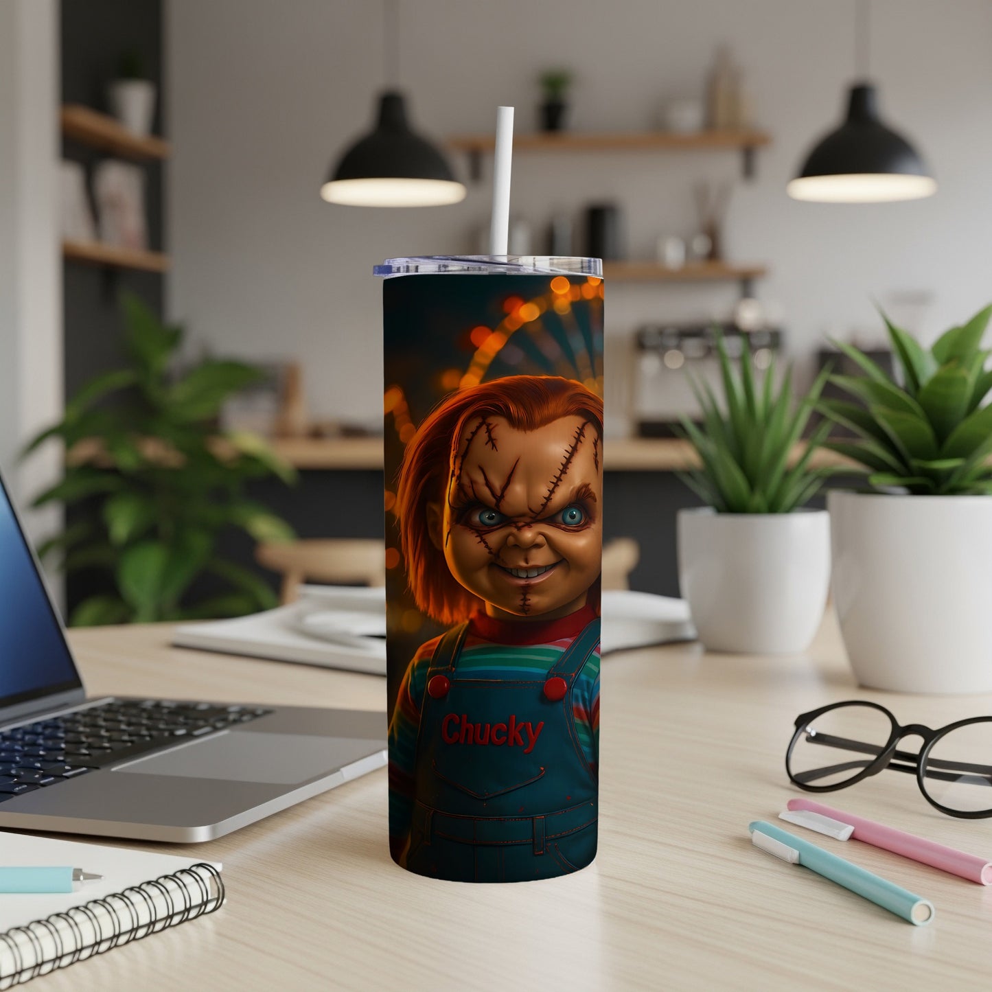 Chucky the doll on a tumbler with a straw, set on a desk.