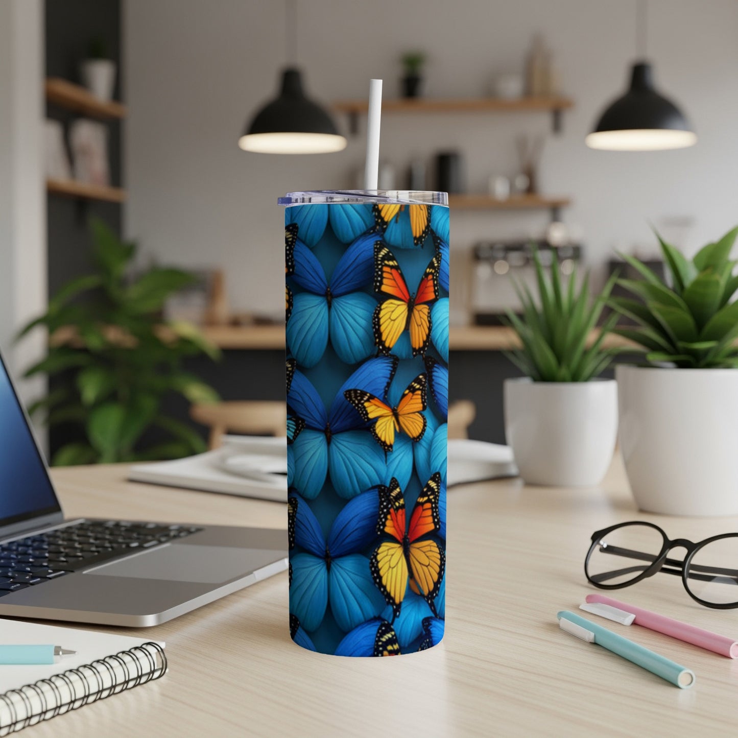Blue tumbler with a repeating butterfly pattern, straw inserted.