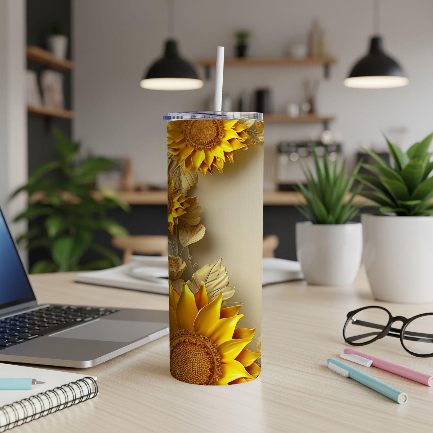 Tall tumbler with sunflower and leaf pattern on light background.