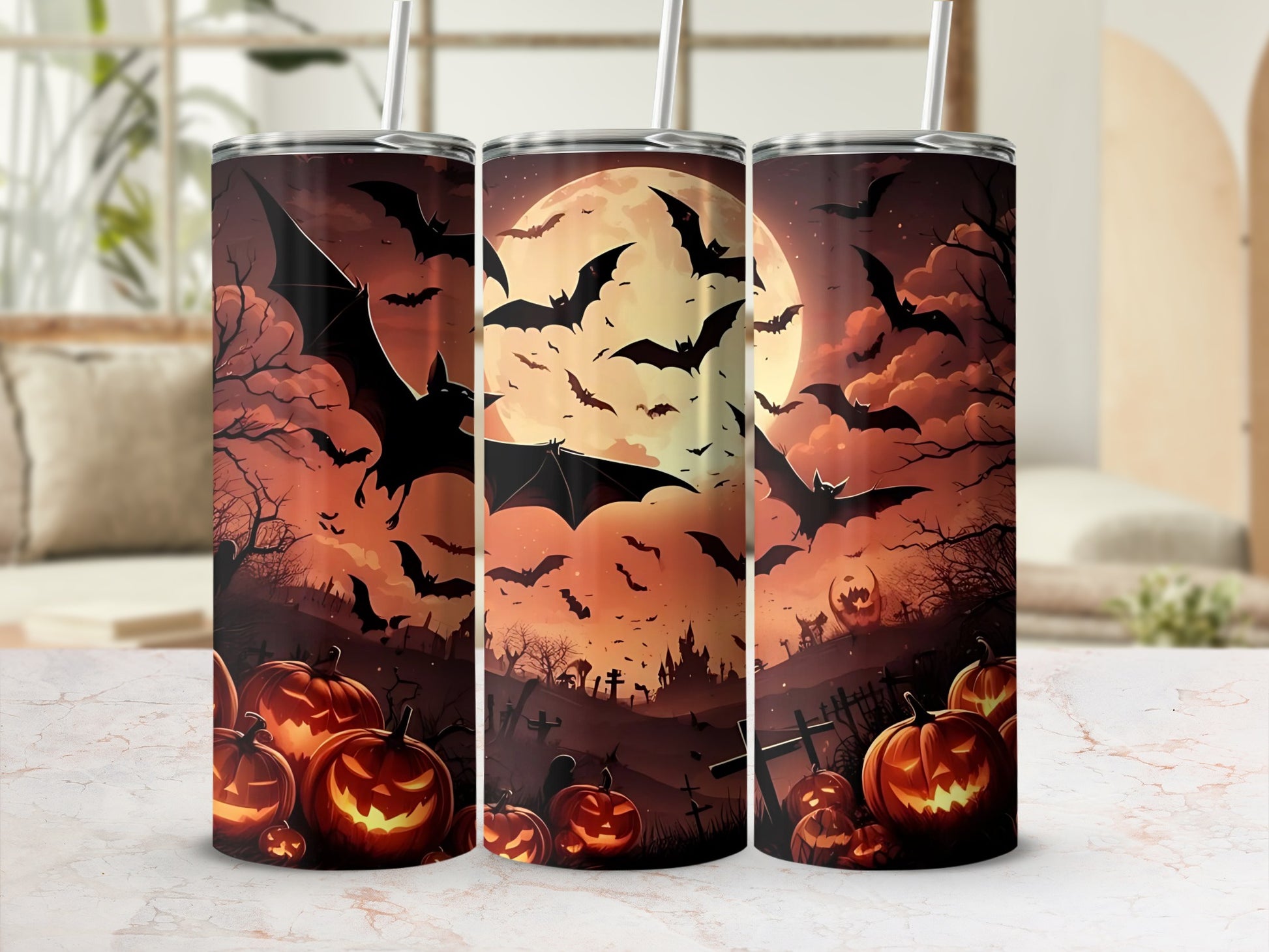 Three tumblers with Halloween designs featuring bats, pumpkins, and a full moon.