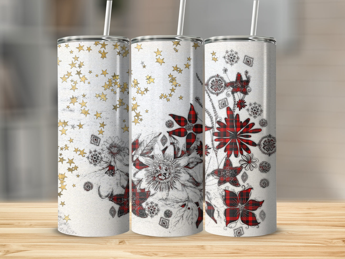 Three tumblers with floral and star designs on a wooden surface.