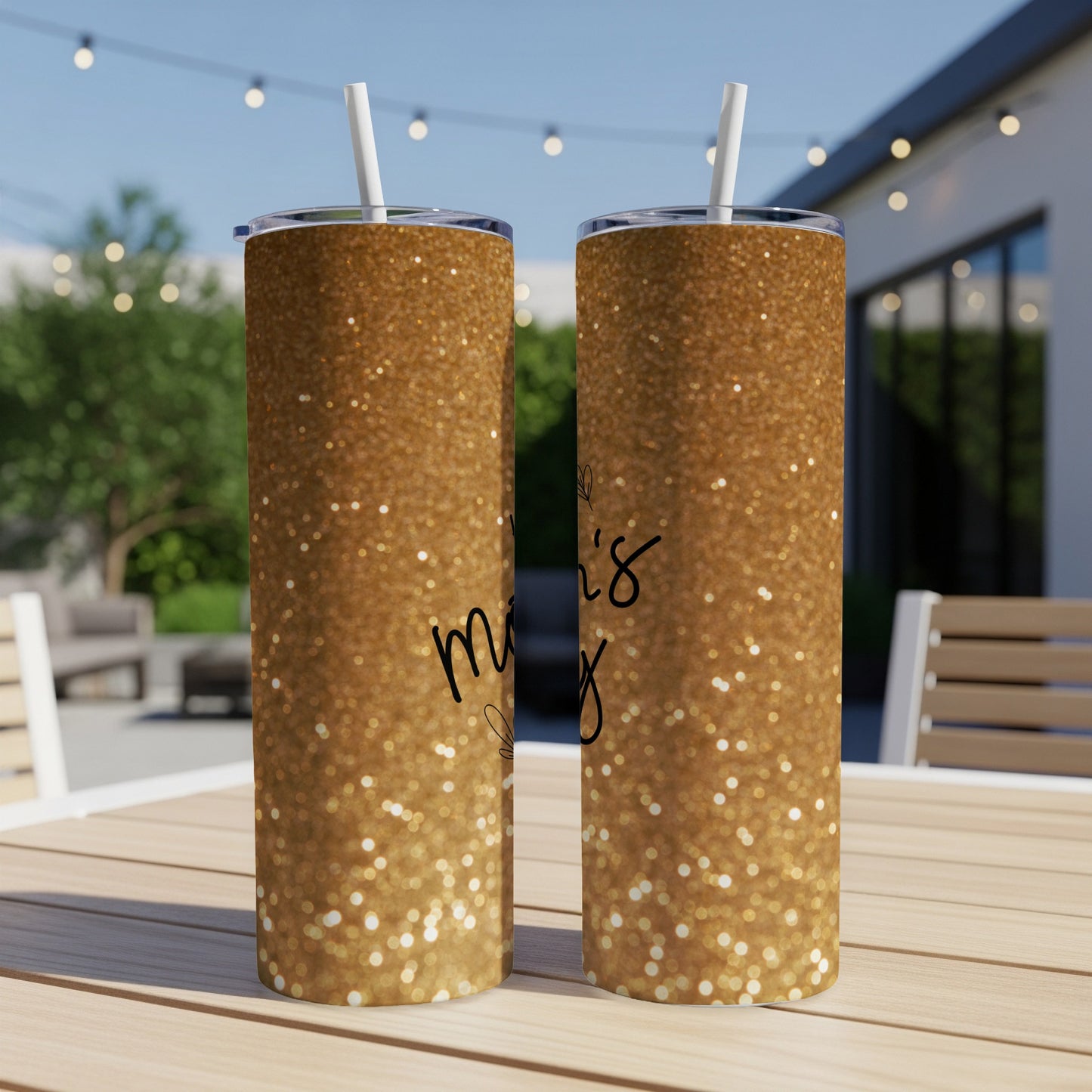 Gold glitter tumbler with "Mom's" text and floral design.