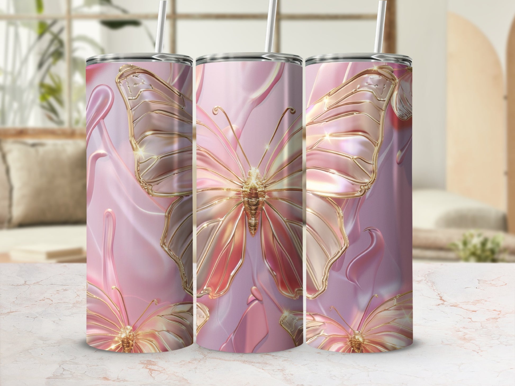 Three pink tumblers with golden butterfly designs on a marble countertop.