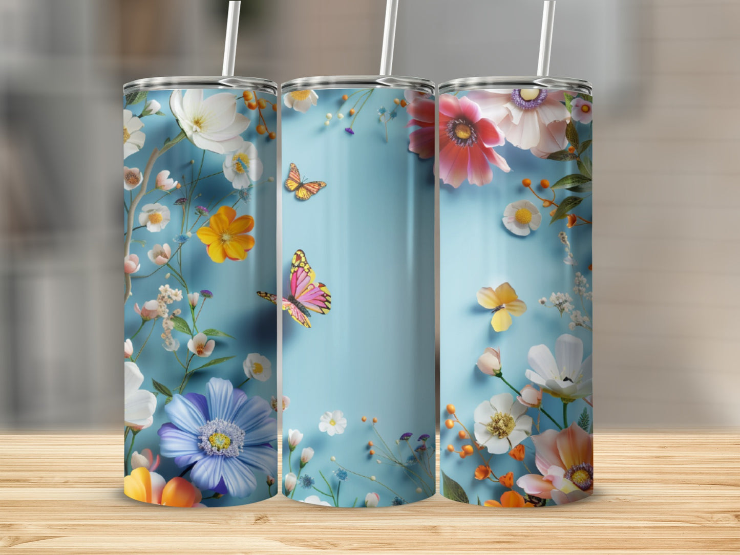 Three tumblers with a light blue background and a colorful floral and butterfly design.