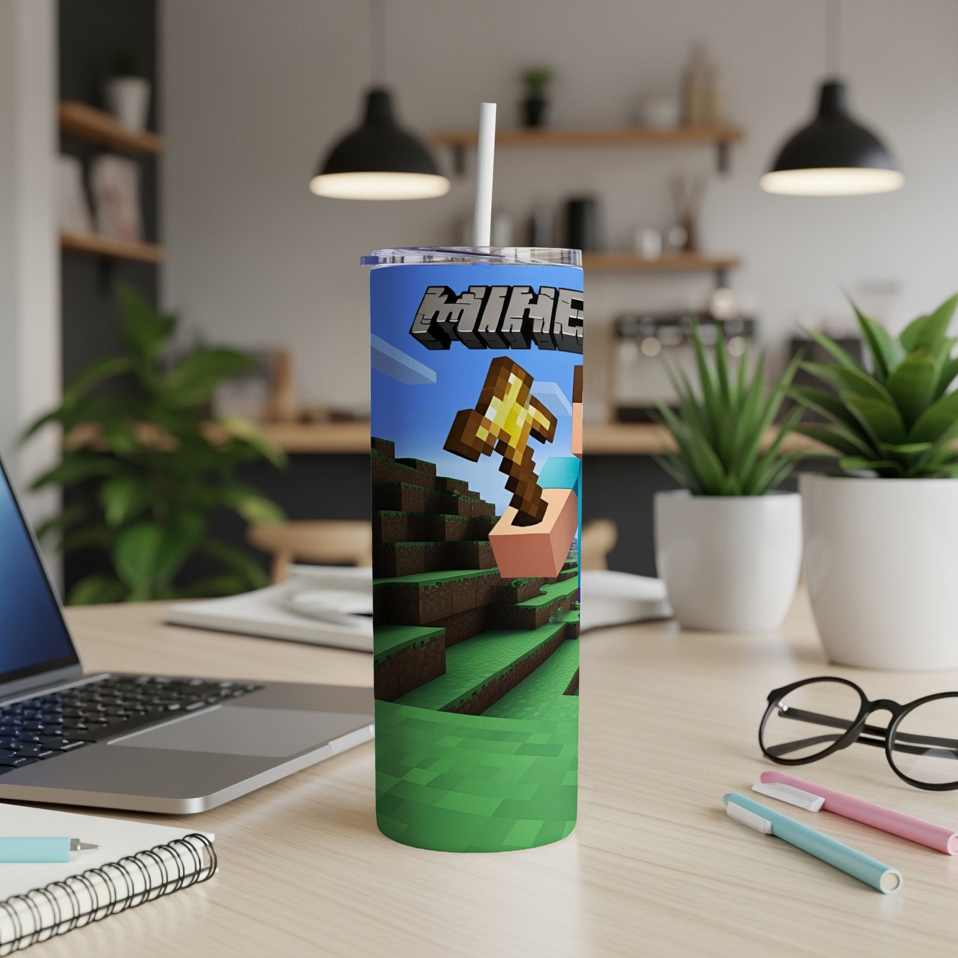 Minecraft tumbler with Creeper character and golden pickaxe on a desk.