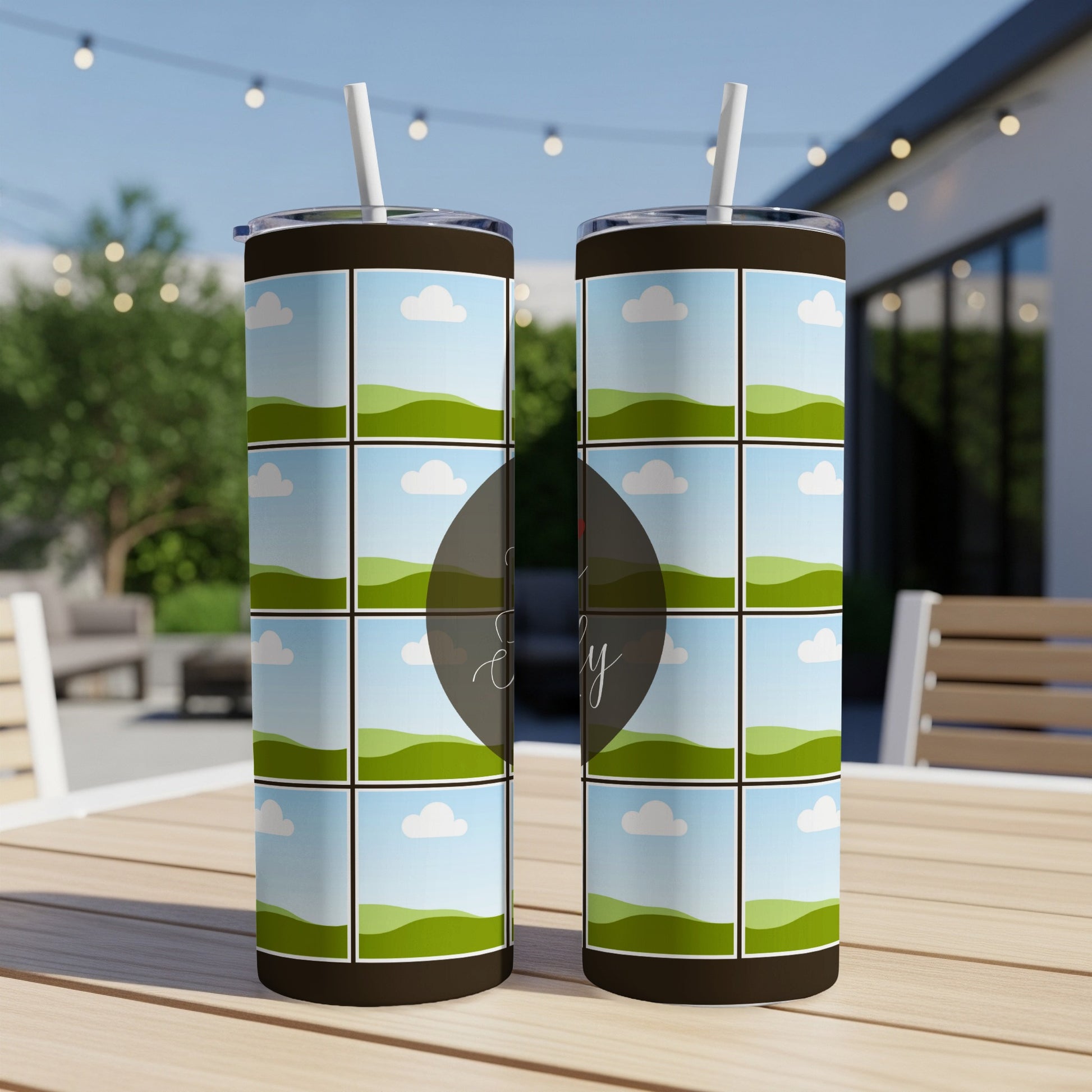 Two tumblers with landscape grid designs sit on a wooden table.