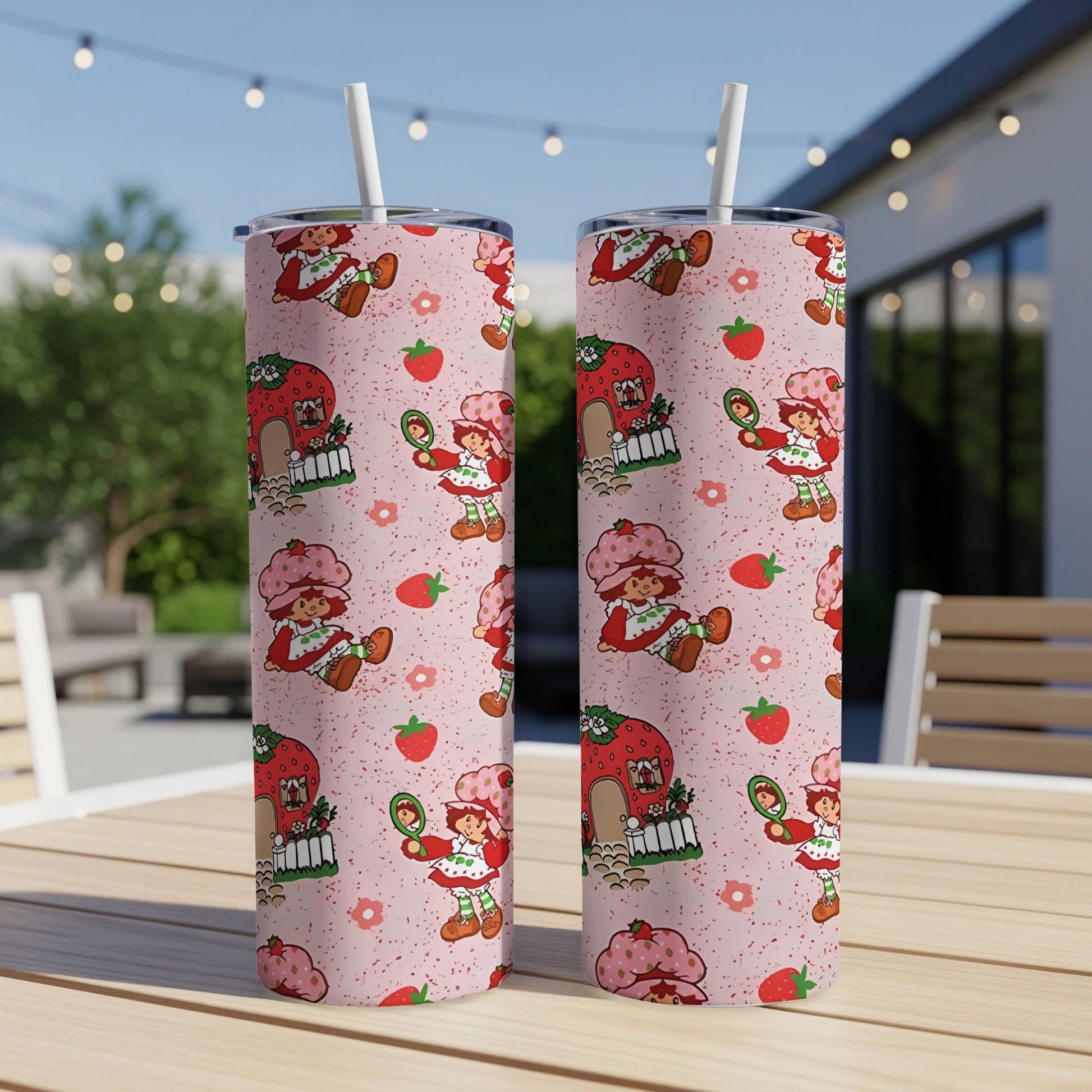 Pink tumbler with repeating Strawberry Shortcake pattern and straws.