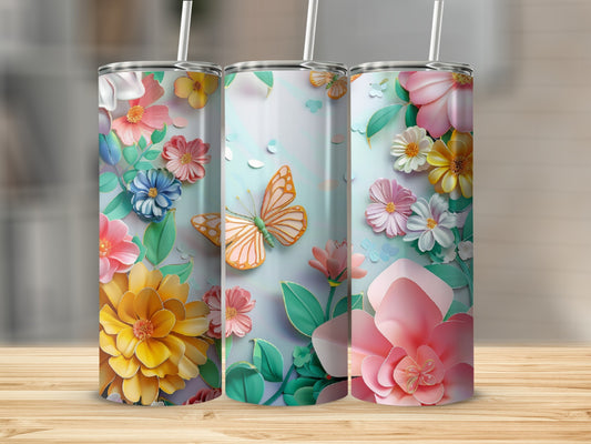 Three tumblers with colorful floral and butterfly designs, on a wooden surface.